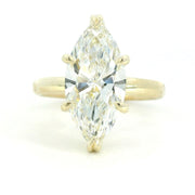 A close-up image of a gold ring with a smooth, polished finish, featuring a single round diamond set in the center. The ring is displayed against a plain white background.