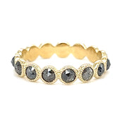 A close-up image of a gold ring featuring a large, oval-shaped blue gemstone set in a four-prong setting, with a simple, polished gold band.