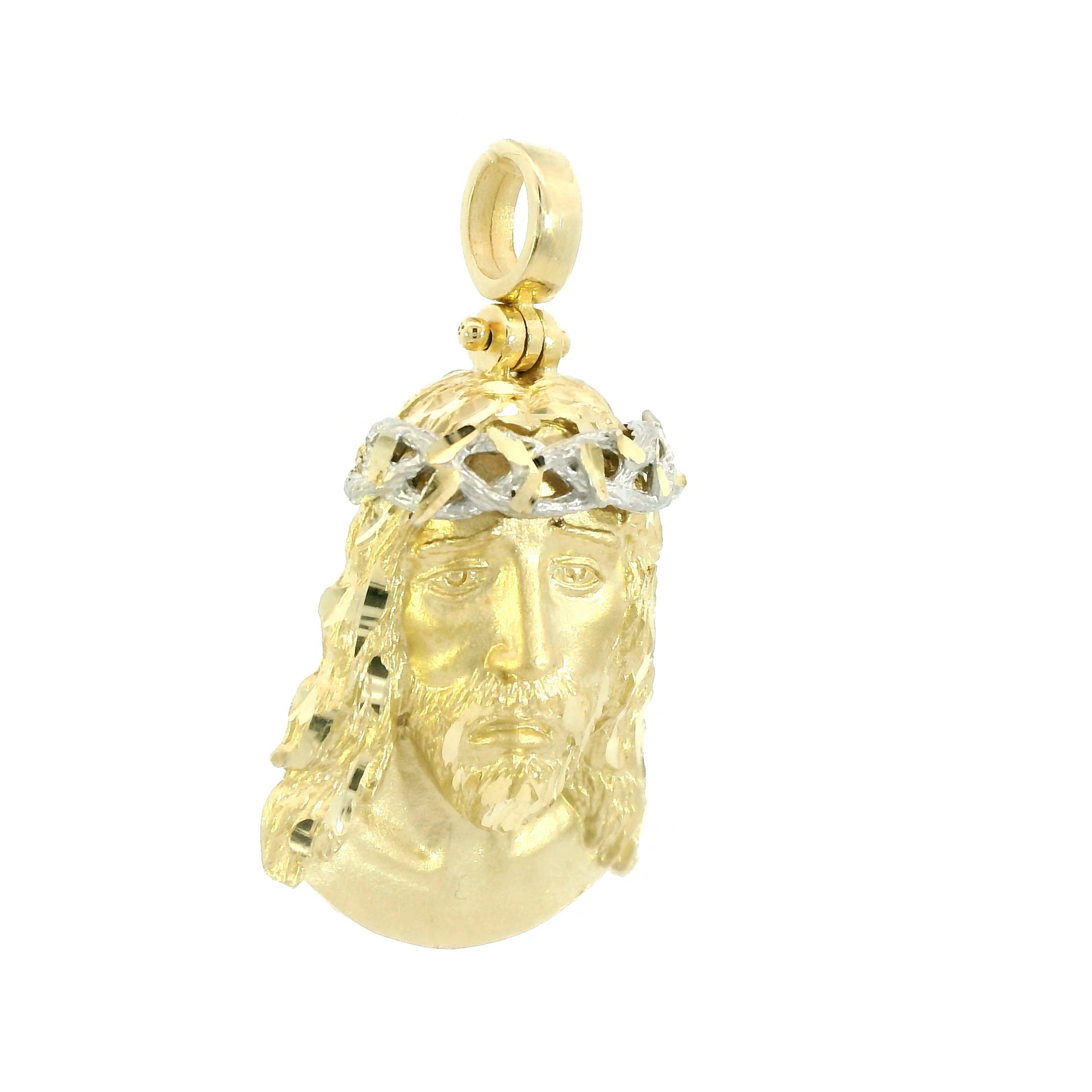 Gold pendant with a face design on a white background