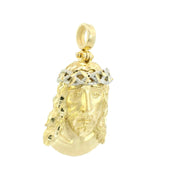 Gold pendant with a face design on a white background