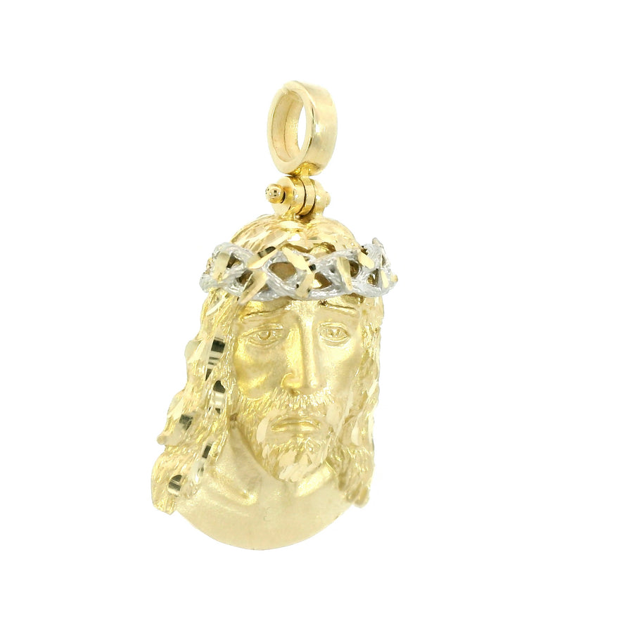 Gold pendant with a face design on a white background