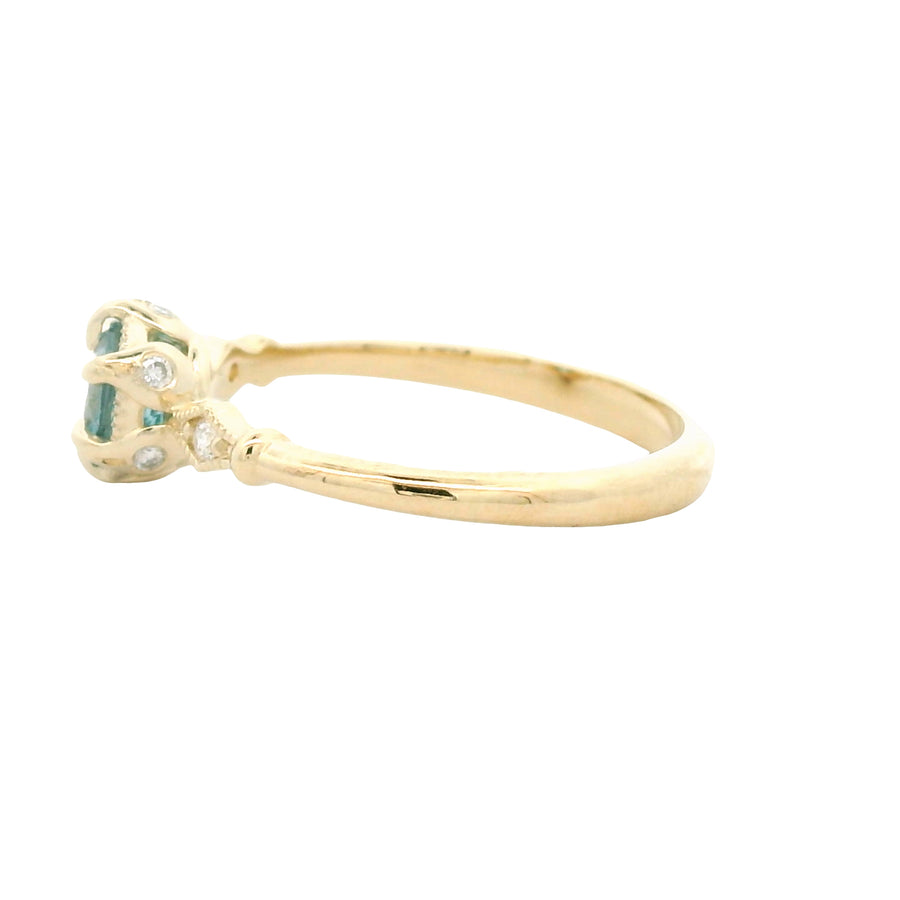 Gold ring with green gemstones on a white background