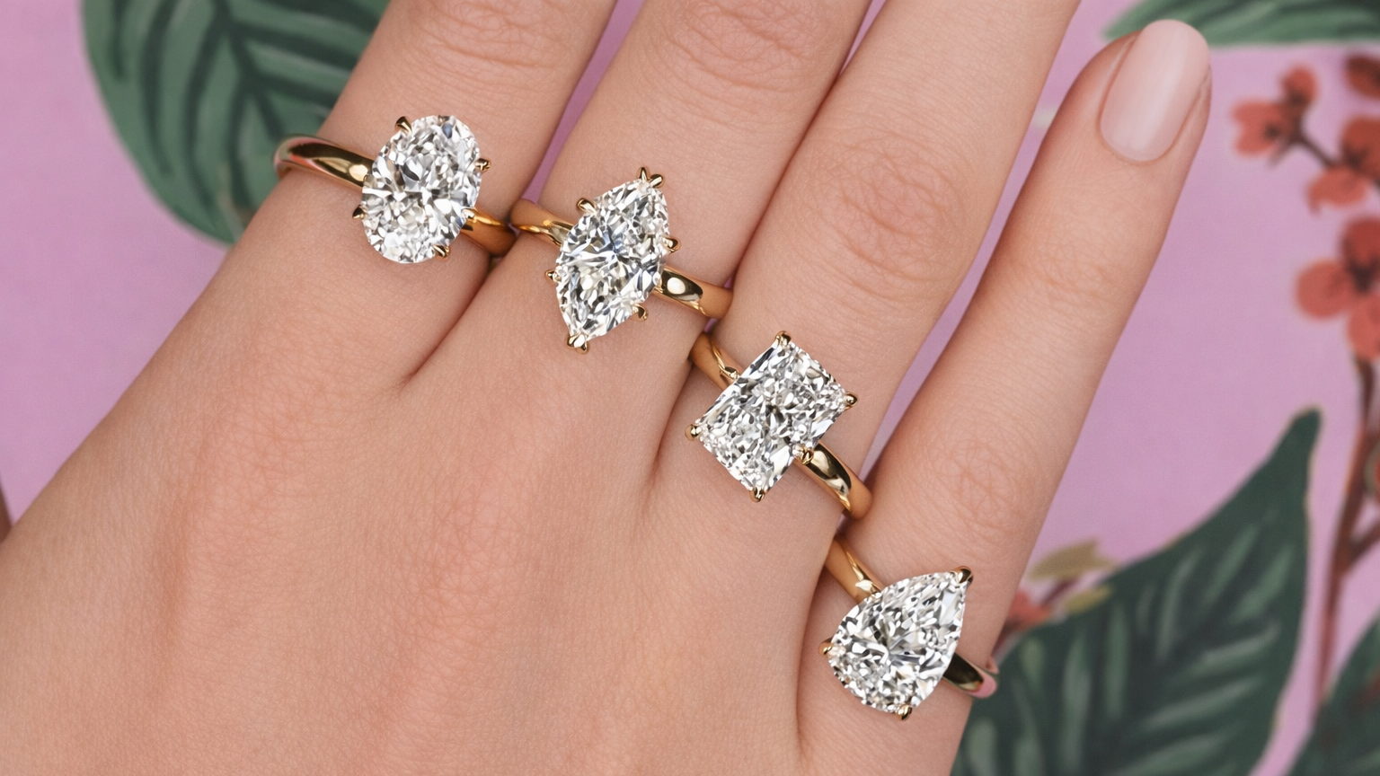Hand wearing multiple diamond rings with a pink floral background